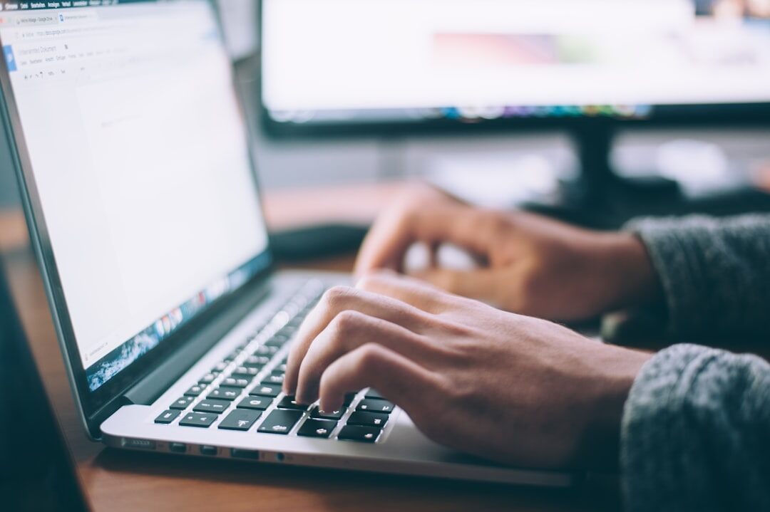 Zbliżenie na dłonie piszące na klawiaturze laptopa